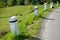 Ranite stone bollards old line the mountain road at the moat on the edge of the white curb with a black stripe in a row turn