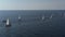 Ranks from yachts of participants of a regatta goes on a start point, is a sailing race at Croatia, reflection of sails