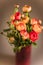 Ranunculuses Bouquet in the red vase on a blured beige background