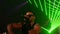 Rap artist in sunglasses perform on stage at party in nightclub. Laser show