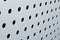 Rapid black big dot pattern on white background, round holes texture on perforated metal panel surface.