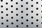 Rapid black dot pattern on gray background, round holes texture on perforated metal panel surface.