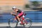 Rapid cycling woman on advanced red racing bike