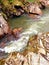 The rapid flow of the river in the forest. Wild creek with turbulent water. The rapid river between rocks and forest in Patagonia