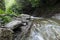 The rapid flow of river water timber. Large rocks on the shore