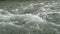 Rapid flow of water from a mountain river is rushing rushing and foaming over