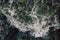 The rapid flow of water with white waves and air bubbles. Top view of a stream of fast flowing water