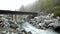 Rapids on quick mountain torrent in Alps, water is flowing over big white boulders and bubbles