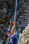 Rappel down on the climbing rope using a descender.