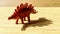 This rare ancient animal is named Stegosaurus in the form of a Maroon Red Toy Statue and looks like a shadow 2