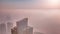 Rare early morning winter fog above the Dubai Marina skyline and skyscrapers lighted by sun aerial.