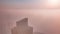 Rare early morning winter fog above the Dubai Marina skyline and skyscrapers lighted by sun aerial timelapse.
