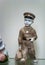 Rare porcelain figurine on a glass shelf. Boy in uniform