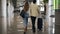 Rare view of couple walking together in airport going on vacation or trip. Travel together. Carry backpack and suitcases