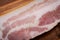 Rashers of Uncured Apple Smoked Bacon arranged on natural wooden cutting board