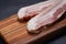Rashers of Uncured Apple Smoked Bacon arranged on natural wooden cutting board