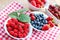 Raspberries and another organic berry fruits in bowls