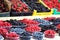 Raspberries, blueberries and blackberries on a market in plastic bowls. Fruits pattern