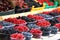 Raspberries, blueberries and blackberries on a market in plastic bowls. Fruits pattern