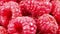 Raspberries close-up, berries in a pile in bulk, rotating, macro, top view.