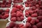 Raspberries in containers on a stall forming a background