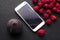 Raspberries, figs and gadget on black shale