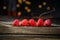 Raspberries in a row on a barn wood board with lights in the background