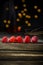 Raspberries in a row on a barn wood board with lights in the background