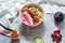 Raspberries smoothie bowl with figs, kiwi and coconut on concrete background