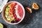 Raspberries smoothie bowl with figs, kiwi and coconut on concrete background