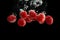 Raspberries splashing into clear water isolated on black background