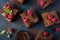 Raspberry brownies served with fresh berries on blue background