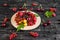 Raspberry, cherry, red currant, blackcurrant on a wooden plate against a dark background