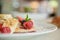 Raspberry close up with slices of banana, berries on a pancake sprinkled with powdered sugar, shallow depth of field