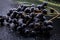 Raspberry clusters next to green and fresh leaves of plants  with a black background ..