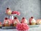 Raspberry cupcakes with white frosting and pink drizzle with a fresh raspberry on top sitting on rustic metal trays on a white