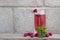 raspberry drink on a gray stone background  walls  glass cup with compote  fresh raspberries on a wooden table  cooling drink