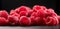 Raspberry fresh berries closeup, ripe fresh organic Raspberries over black background, macro shot