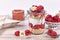 Raspberry fruit dessert with skyr yogurt, granola and puffed quinoa grains layered in jar