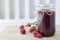 Raspberry jam in a jar on table