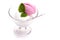 Raspberry and lemon ice cream scoop in a glass with a spoon and mint leaf