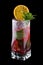 Raspberry Mojito decorated with orange chips. On black background
