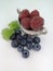 Raspberry in an old antique silver bowl. Blueberry and lemon balm leaf. White background.