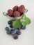 Raspberry in an old antique silver bowl. Blueberry and lemon balm leaf. White background.