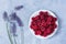 Raspberry plate lavender on a gray table top view. Ripe raspberries in close-up