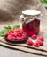 Raspberry preserve in glass jar and fresh raspberries