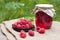 Raspberry preserve in glass jar and fresh raspberries