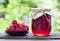 Raspberry preserve in glass jar and fresh raspberries