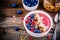 Raspberry smoothie bowl with granola, chia seeds, almonds, fresh blueberries and pomegranate