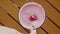 Raspberry Smoothie in Glass. Close up of Woman Hand Stirs Fresh Pink Berry Drink